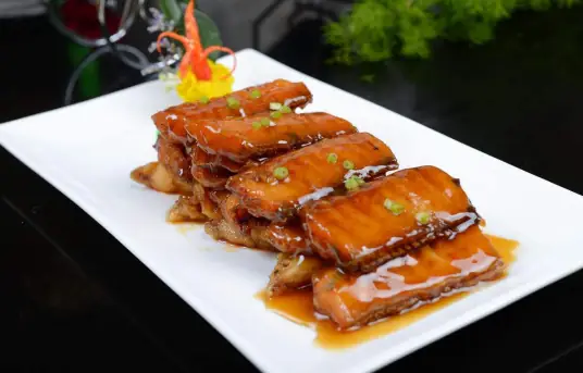 红烧带鱼色酱红光亮，鱼肉细腻鲜嫩，口味咸中带甜